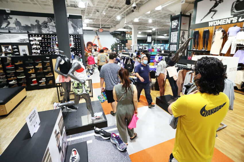 GARDEN CITY, NEW YORK - JULY 10:  Customers wait in line to pay for itemsat Dick's Sporting Goods store at Roosevelt Field Mall which reopened today on July 10, 2020 in Garden City, New York.  Malls across the state were ordered to close March 19, and other businesses deemed nonessential were ordered to close the same week, to help stop the spread of the coronavirus.  The openings follow Gov. Andrew M. Cuomo’s announcement Wednesday that malls outside of New York City can open if they have high-efficiency air filtration systems to help control the spread of the virus.   (Photo by Al Bello/Getty Images)